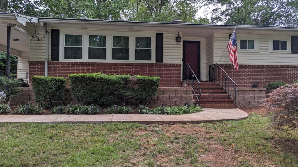 Two retaining walls built with Rockwood Buff block in front of home with partial brick facade.